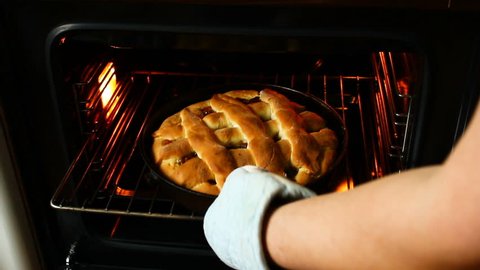Barmy apple jam pie in an oven.