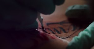 Milan/Italy-01.02.2019:Slow motion of professional master of the art of tattooing doing a tattoo to his customer with a black ink in the workshop.Concept of alternative lifestyle, art, creative