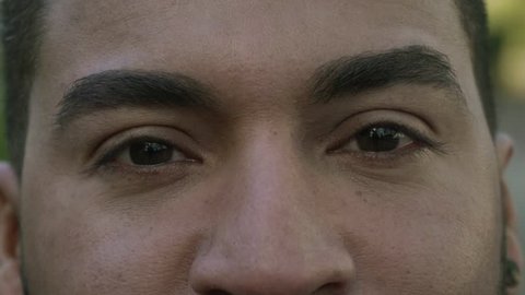 Beautiful brown male eyes looking at camera. Close-up partial view of handsome happy man looking at camera. Emotion concept