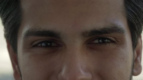 Beautiful male eyes looking at camera. Close-up partial view of happy young Indian man looking at camera. Emotion concept