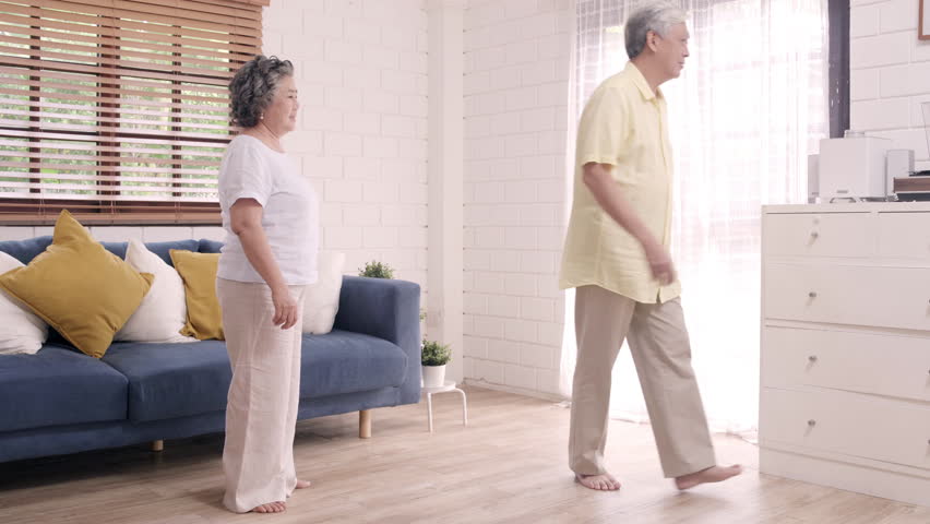 Asian elderly couple dancing together while listen to music in living room at home, sweet couple enjoy love moment while having fun when relaxed at home. Lifestyle senior family relax at home concept. Royalty-Free Stock Footage #1023749500