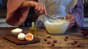 slow motion of female cook whipping eggs for dessert