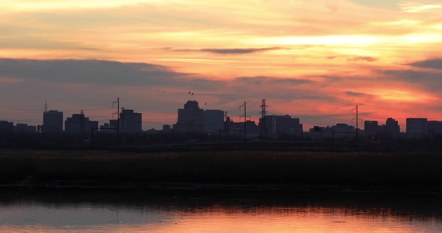 The Newark, New Jersey skyline and the NJ Turnpike vehicular traffic silhouetted during sunset along the Hackensack River in Secaucus, NJ. 
