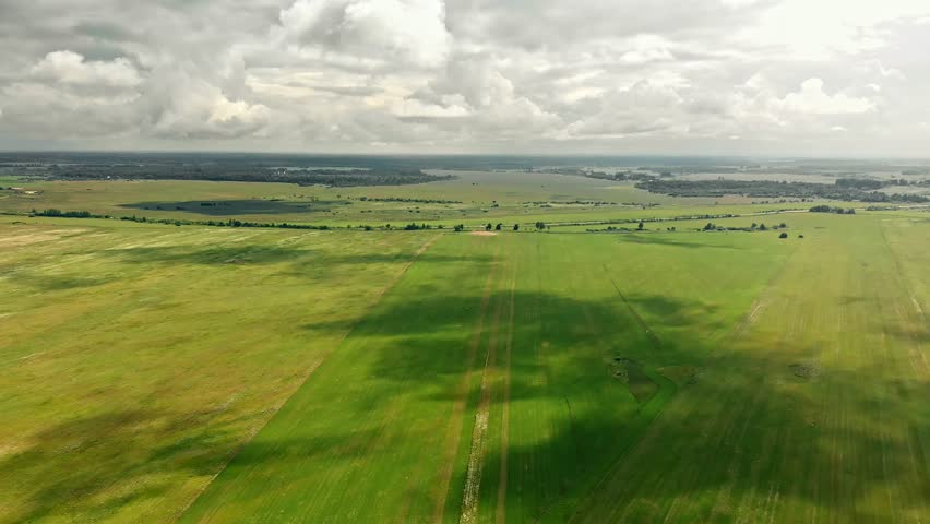 Shadows of the clouds move over the green fields