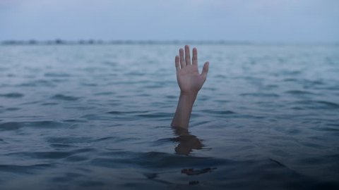 Hand of a drowning man sinks into the water, concept of a person mired in debt and unable to help himself