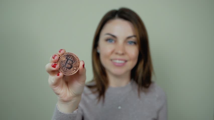 Golden Bitcoin on women hand show to the front