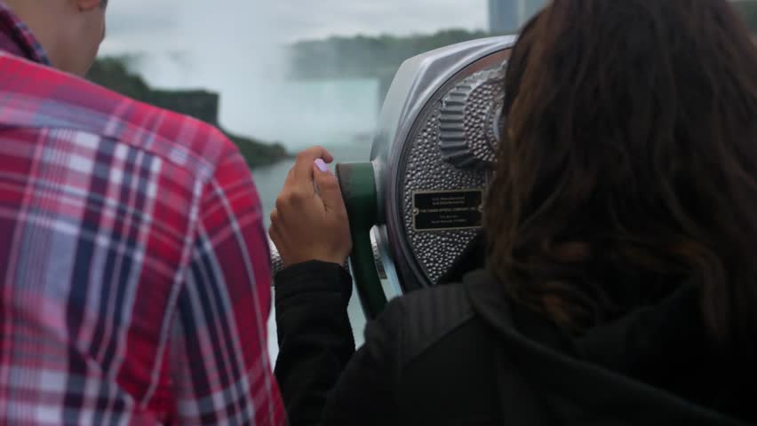Couple Looks Through Viewfinder at Niagara Falls, Tourists