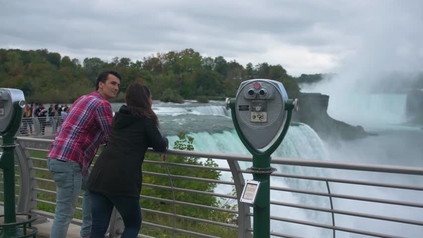 Couple on Bridge Looking at Niagara Falls, Tourists Viewfinder