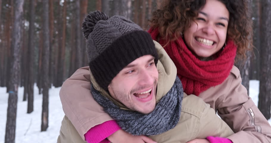 Man giving piggyback ride to woman in winter