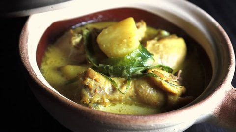 Cinematic Footage. Chicken in thick coconut gravy with turmeric and chilli, known as Masak Lemak Cili Api in Malaysia.