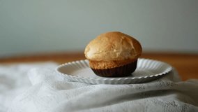 A cup bread in a paper plate rotating on a fluffy white cloth 