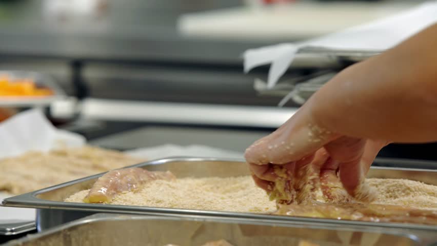 chicken breast getting ready in bread crumb and eggs
