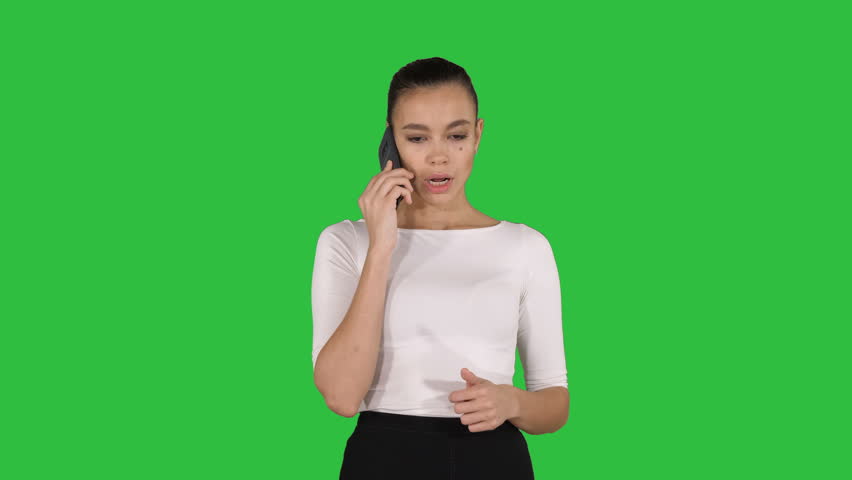 Dolly shot of young unhappy woman talking on the mobile phone in the ...