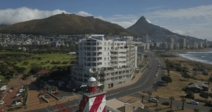 4K sunny day aerial video of Green Point Lighthouse, waterfront, park, promenade. Green Point is Cape Town's upmarket Atlantic Seaboard residential suburb, Cape Peninsula, Western Cape, South Africa