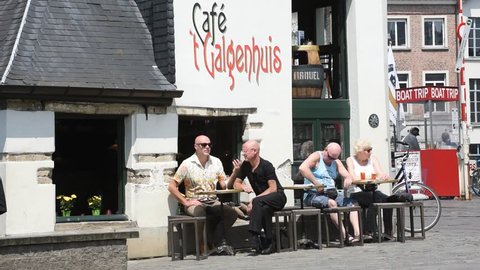 Ghent, Belgium - June 6, 2016. Tourists on pavement cafe at 't Galgenhuisje, smallest and oldest cafe in Ghent, Flanders, Belgium