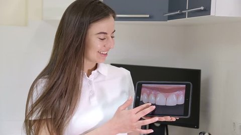 Dentist girl with a tablet in their hands, treating teeth