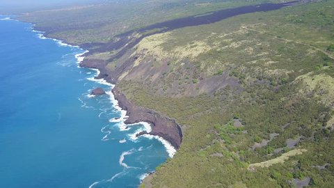 drone flying over coast of big island hawaii looking down at ocean and cliffs