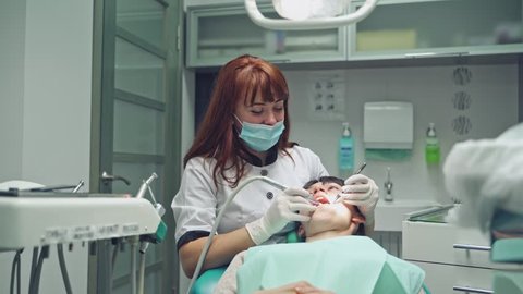 Dentist and patient in dentist office. Dental clinic.