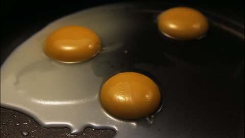 the process of cooking fried eggs on a griddle, on vegetable oil. Bright and attractive