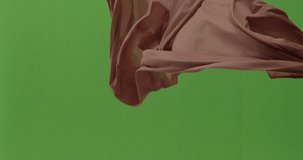 Abstract material floating cloth fabric against green screen in slow motion
