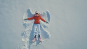 A woman throwing herself on the snow and making angels - Powered by Shutterstock - Get 15% off with code: PIKWIZARD15
