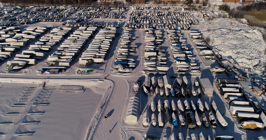 View of the small boats marina at Espoo Finland with boats on shore for winter storage, on a snowy winter day