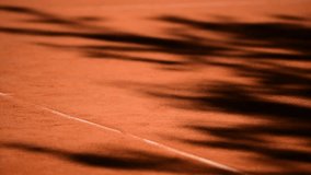 Tree shadows are seen on a tennis clay court
