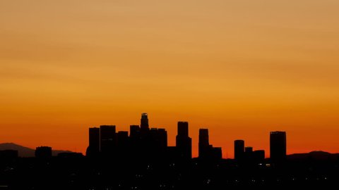 4K Time lapse sunrise over downtown Los Angeles skyline silhouette with red and orange colored sky