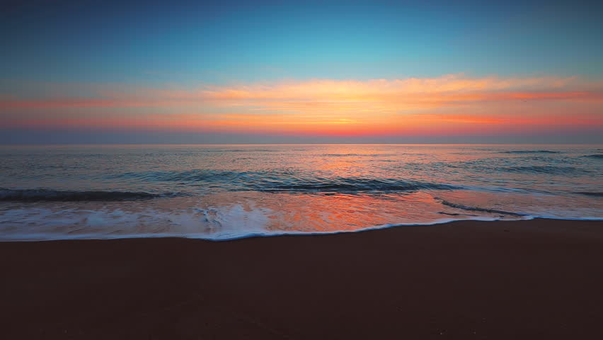 Sunrise over the sea and beach. Waves washing the sand. | Shutterstock HD Video #1023884971