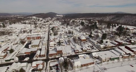 Aerial camera flying over the snow covered town of Hancock, Maryland on the banks of the Potomac River.