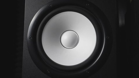 Close up of moving modern sub-woofer on recording studio. White round audio speaker pulsating and vibrating from sound on low frequency. Work of high fidelity loudspeaker membrane. Slow motion