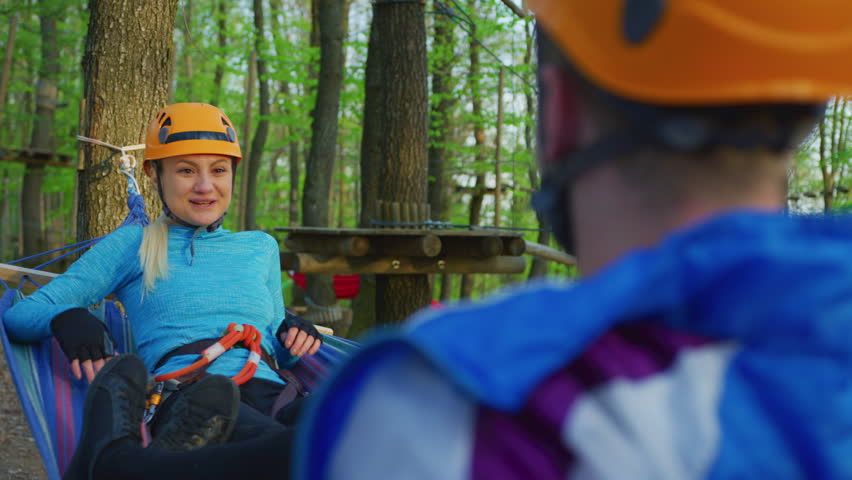 Couple relaxing in a hammock in an adventure park.
