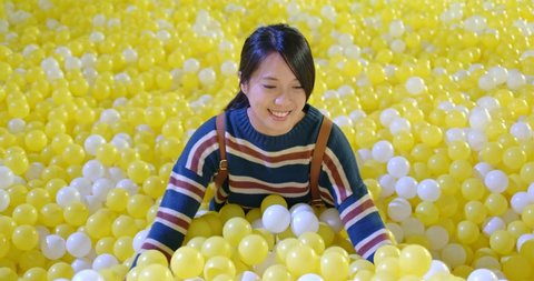Woman play inside the ball pit