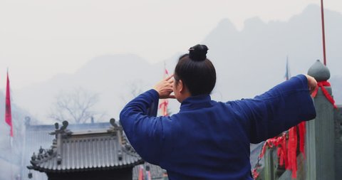 A senior monk of Wudang mountain Monastery in China demonstrates Tai Chi martial arts. Slow motion hand held, Red Cinema camera. 