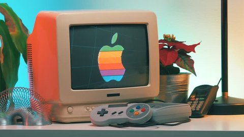 MONTREAL, CANADA - February 2019 : 
 Apple Macintosh retro logo on Old Computer - TV Screen while the camera is slightly turning around the vintage crt monitor.