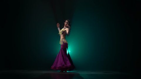 Woman belly dancer arabian dancing . Smoke background