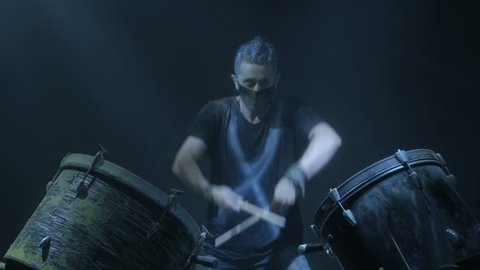 The man is playing snare drum in blue light background.