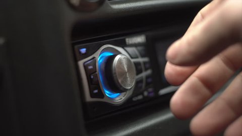 Men Switches And Listens The Radio In The Car