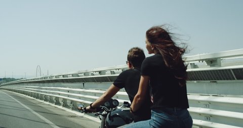 Closeup couple on the motorcycle have a ride they are happy in the summer , on the motorway lady holding lovely the man from the back. shot on red epic