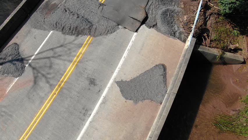 Drone footage reveals devastation on bridge and roadway after floodwaters hit the bridge in Lancaster County, PA. Road pavement displaced by the force of water, natural disaster, climate change