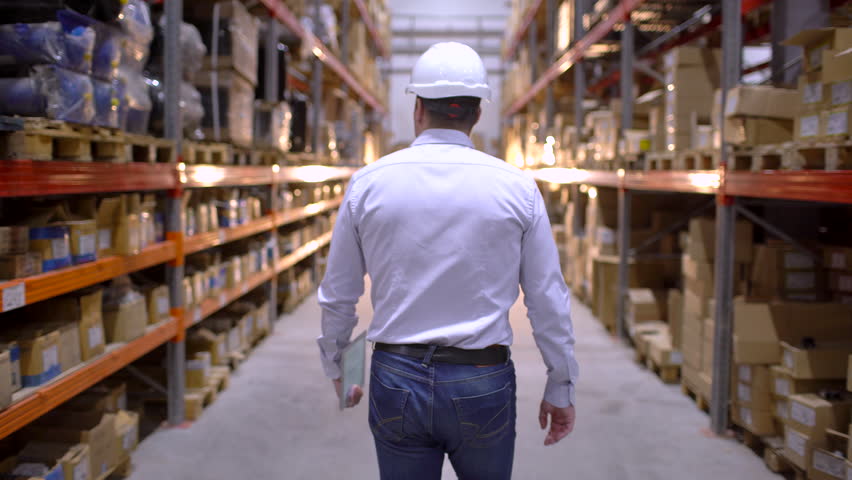 Follow footage of employees male warehouse worker engineer in hard hat working. walking through logistics center warehouse factory construction site logistics architect businessman man builder indoors Royalty-Free Stock Footage #1023937292