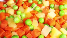 Frozen mix vegetables peas potato carrot cubes food closeup texture pattern seamless looping rotating video footage hd resolution.