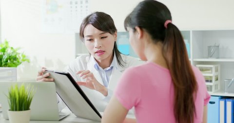 woman doctor ophthalmologist discussing with a patient by digital tablet pc in hospital
