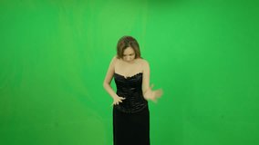 Young woman with black dress casting spells at magic waves green screen
