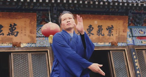 Monk of Wudang mountain Monastery in China demonstrates Tai Chi martial arts. Slow motion hand held, Red Cinema camera. Note: Chinese symbols, Taoism, practice has a purpose don't forget core belief. 