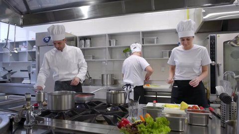 busy cooks and kitchen chef working in professional kitchen
