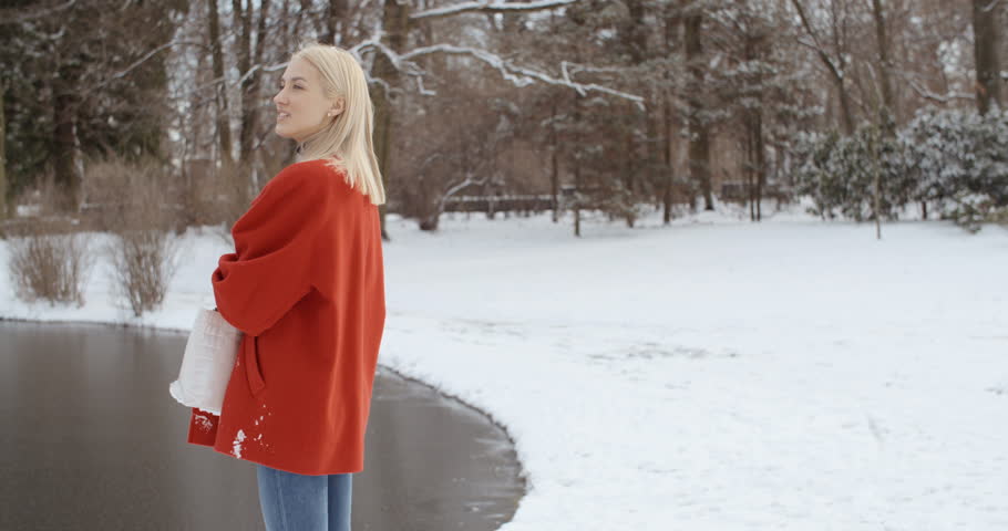 Happy young girl enjoying winter in a city park.