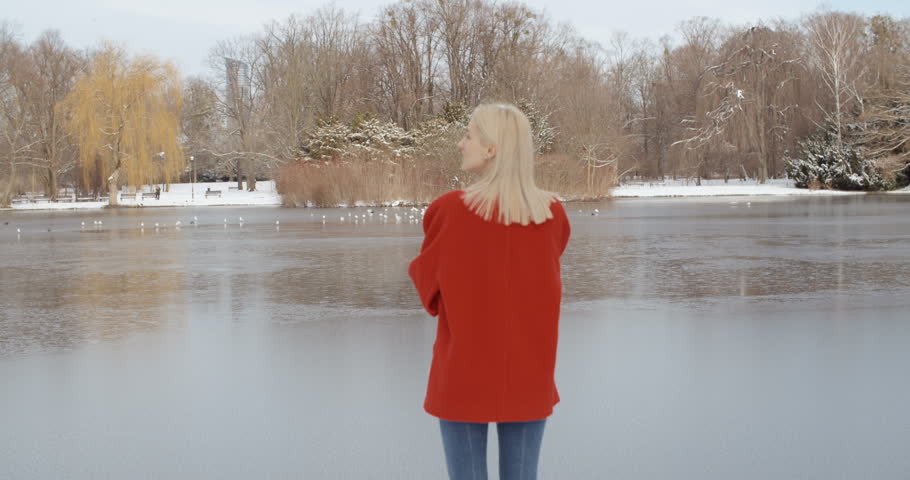 Happy young girl enjoying winter in a city park.