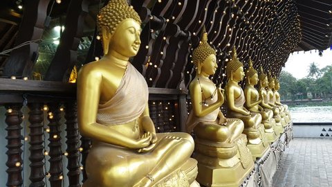Golden Buddhism statues in buddhist religion temple with wooden architecture in Colombo Sri Lanka in vesak day recorded in movement.