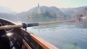4K Video - A paddle in the water on a sunny day - Rowing the boat with island Lake Bled in the background- Lake Bled, Slovenia